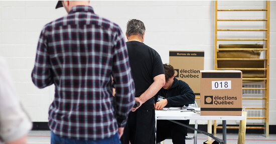 Des gens attendent au bureau de vote.