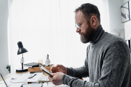 Homme assis à son bureau faisant des calculs